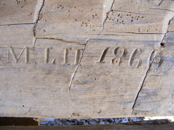 Antique log beam with original builders intials and date of 1860.